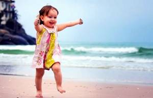 Девочка бегает по пляжу