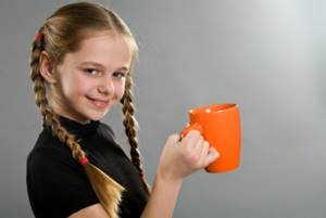 Девочка-подросток держит в руке чашку с вкусным какао