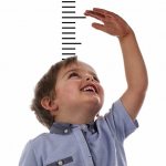 Мальчик измеряет свой рост