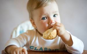 маленький ребенок ест хлеб
