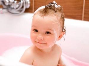 Малышка в ванной с мокрыми волосами перед вычесыванием корочек