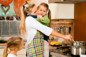 мама готовит с ребенком на руках