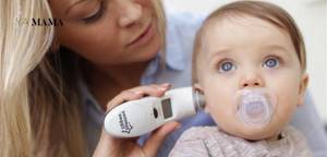 Мама измеряет ушную температуру ребенка