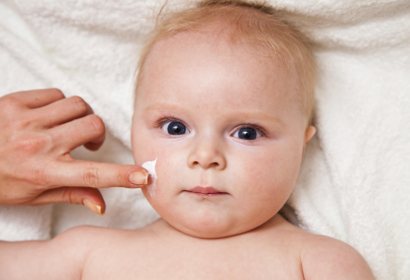 Нанесение крема на лицо ребенка