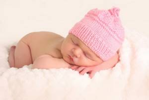 Новорожденный кроха в шапочке перед вычесыванием корочек
