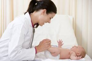Педиатр проверяет рефлексы у новорожденного