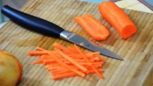 Перед тем как сварить молочный суп, нарежьте морковку.
