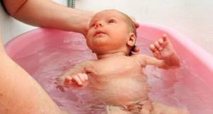 Посмотрите видео о том, как купать новорожденного ребенка в ванночке.