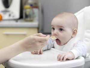 Ребенка в возрасте 5 месяцев кормят с ложки
