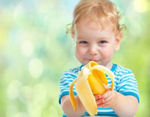 ребенок держит банан