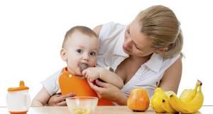 Ребенок ест мясо а фрукты на столе