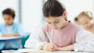 ребенок пишет диктант в школе