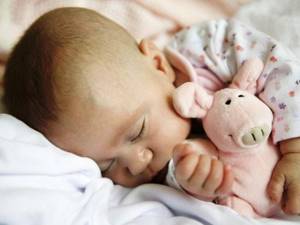 Ребенок во сне обнимает игрушку
