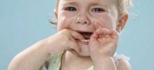 Темное пятно на десне около зуба у ребенка