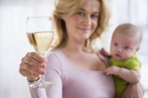 женщина с ребенком на руках и бокалом вина